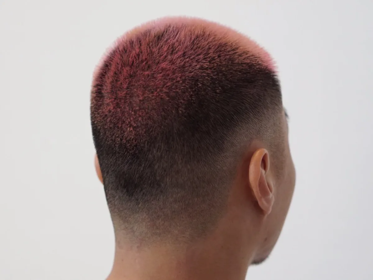 Pink-toned buzz cut with a faded undercut, back view
