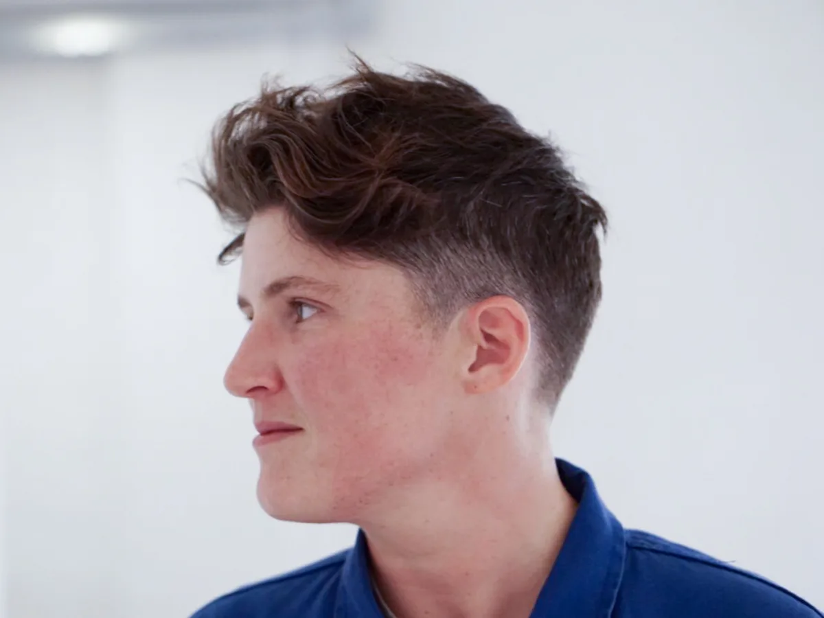 Wavy textured quiff with a low taper fade, profile view